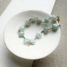 Aquamarine bracelet with gold clasp in a white dish