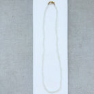 lemon quartz gem necklace on a light gray fabric background