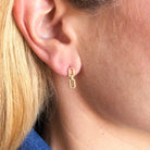 Close up of woman wearing a chain link stud in gold