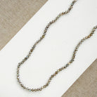 Small labradorite gems knotted necklace on a white surface with a beige background