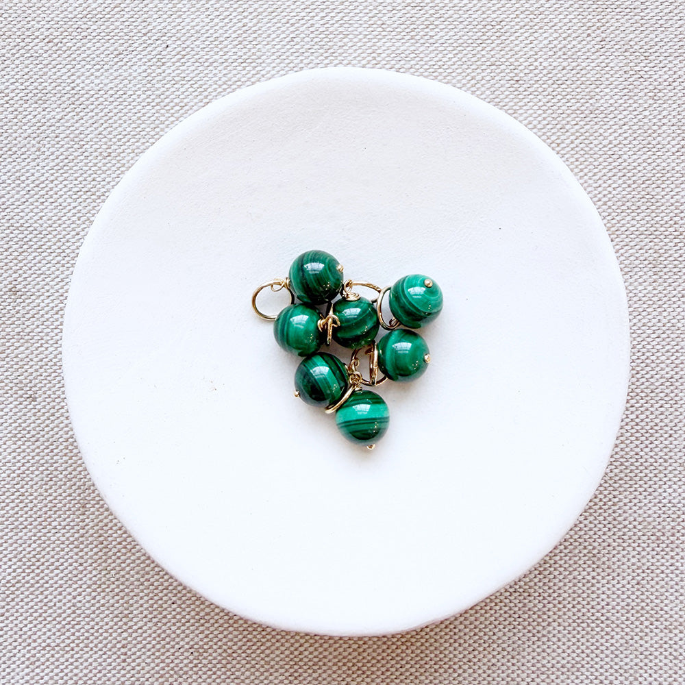 Dish of small round malachite gem charms