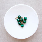 Dish of small round malachite gem charms