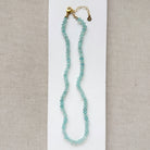 Aqua chalcedony necklace on a white card against a beige background