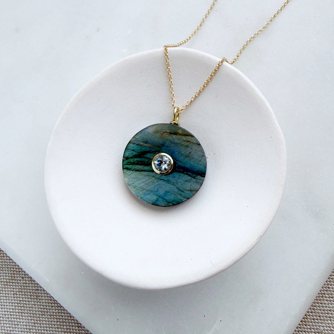 Labradorite pendant with small inset blue quartz stone on a gold chain