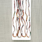 Spinel knotted necklace on a white plate