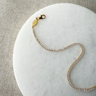 Clasp detail on a gold and CZ micro style tennis bracelet