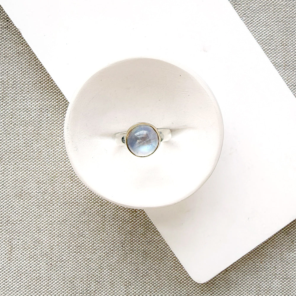 Round moonstone mixed metal ring in a dish