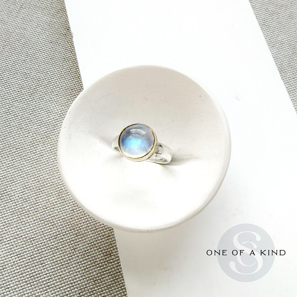 Round moonstone mixed metal ring in a dish