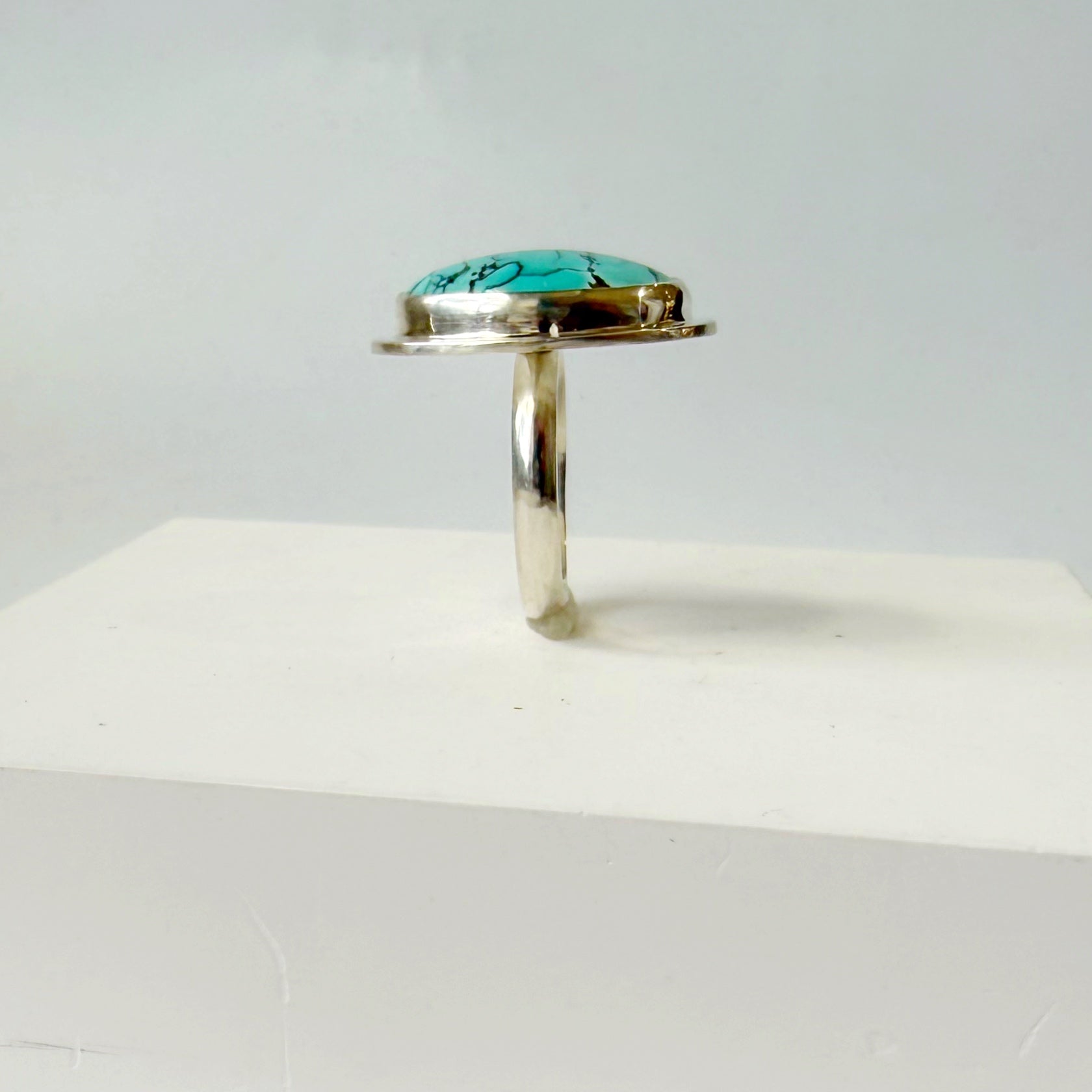 Side view of Nevada turquoise ring on a white background