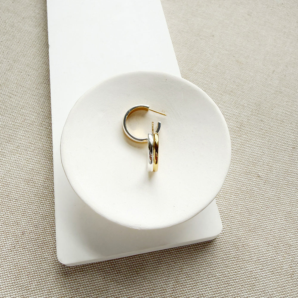 Mixed Metal hoop in a white dish on a light colored background