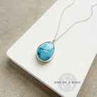 Golden Hills turquoise pendant necklace in sterling silver  on a white card with 'One of a Kind' branding.