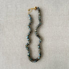 Necklace with labradorite gemstones against a beige fabric background