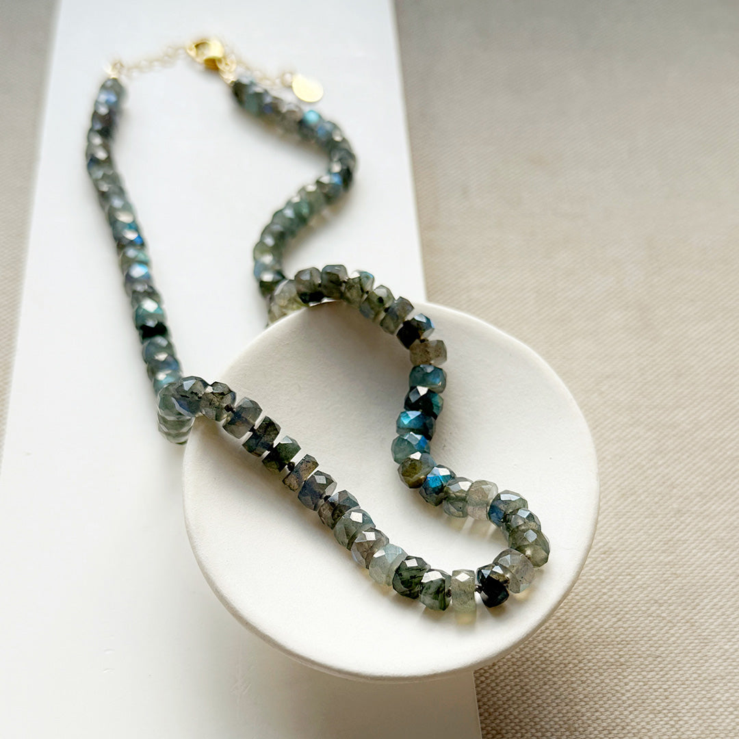 Labradorite knotted necklace with faceted gemstones on a white dish