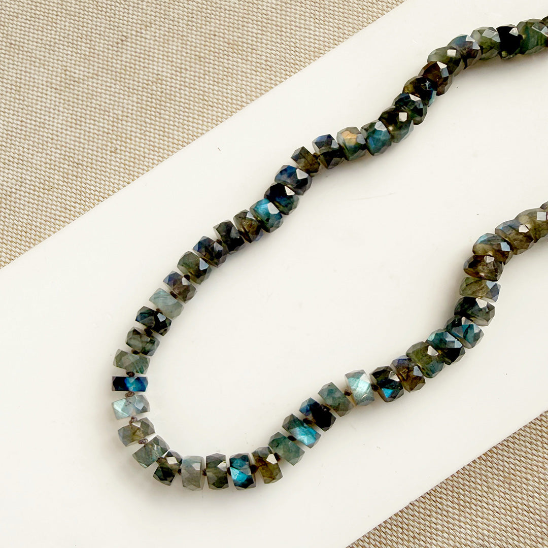 Labradorite knotted necklace with faceted gemstones on a white plate