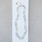 Chunky silver chain necklace on a gray background
