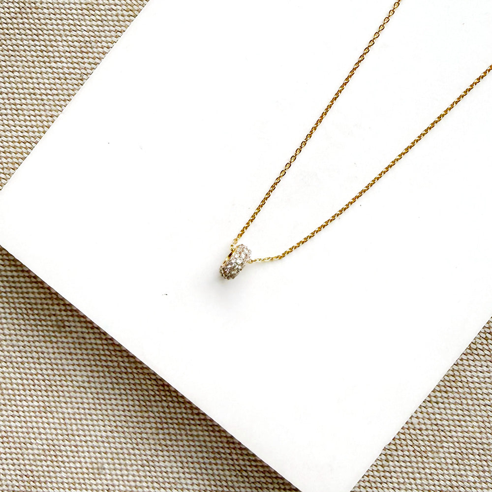 Diamond pave wheel charm on a gold chain