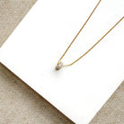 Diamond pave wheel charm on a gold chain