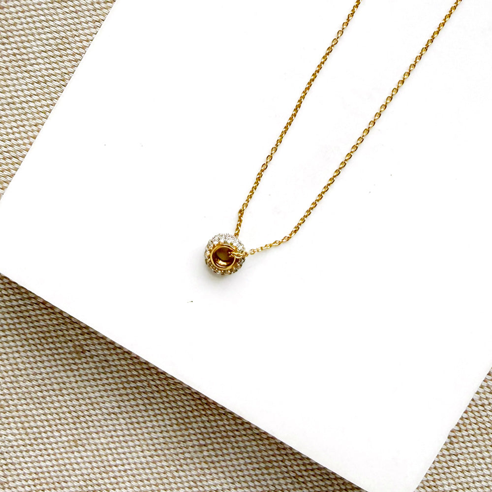Diamond pave wheel charm on a gold chain