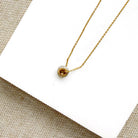 Diamond pave wheel charm on a gold chain