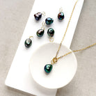 Pearl charm on a chain in a dish with pearl charms scattered around