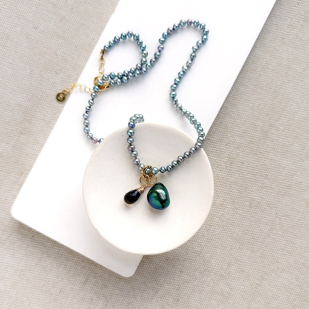 Pearl necklace in a dish with pearl charm