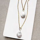 Two gold chains with tear drop shaped pearl charms