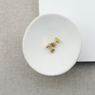 Small hammered disc studs in gold on a white dish