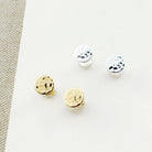 Small hammered disc studs in gold and silver on a white background
