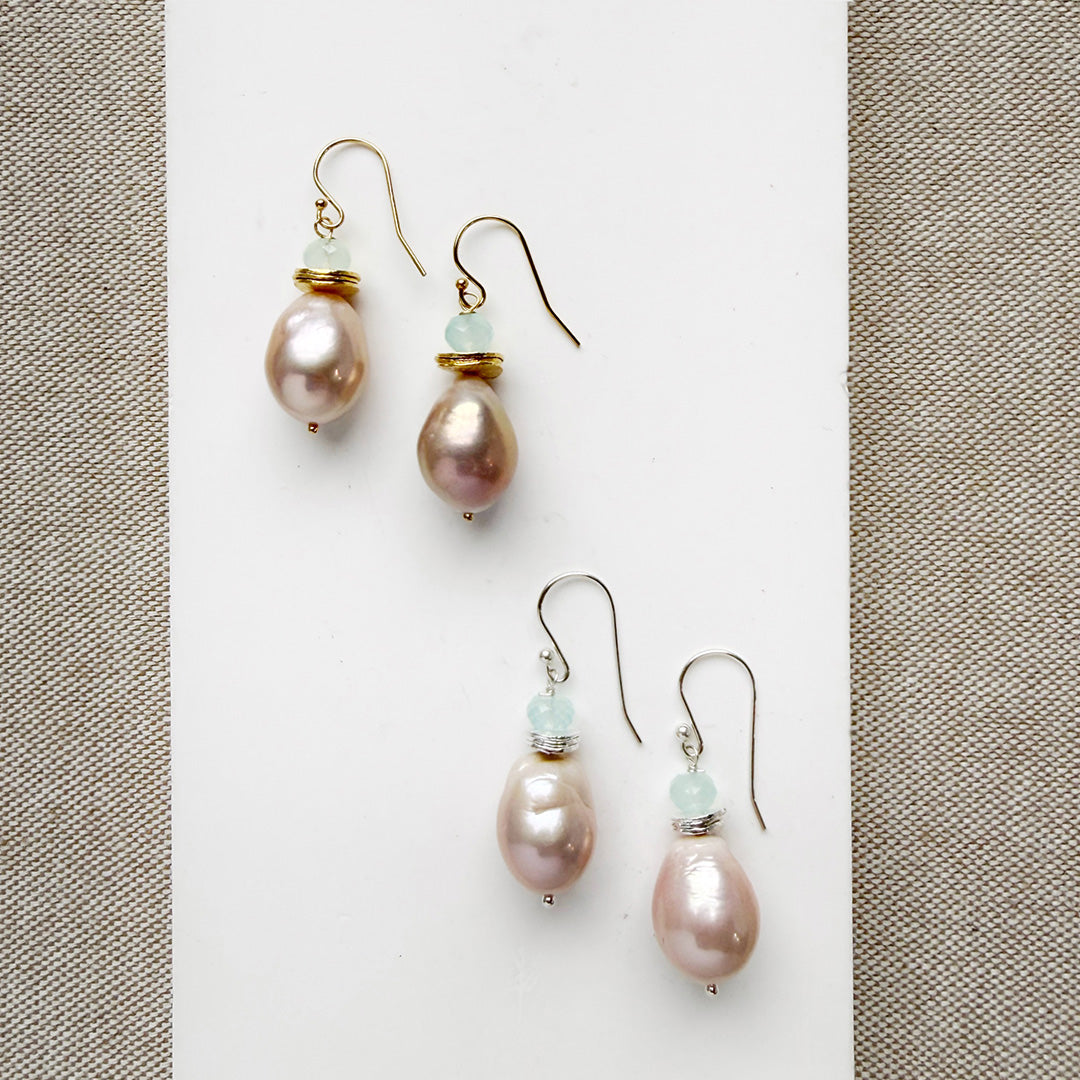 Pink pearl drop earrings on a white background