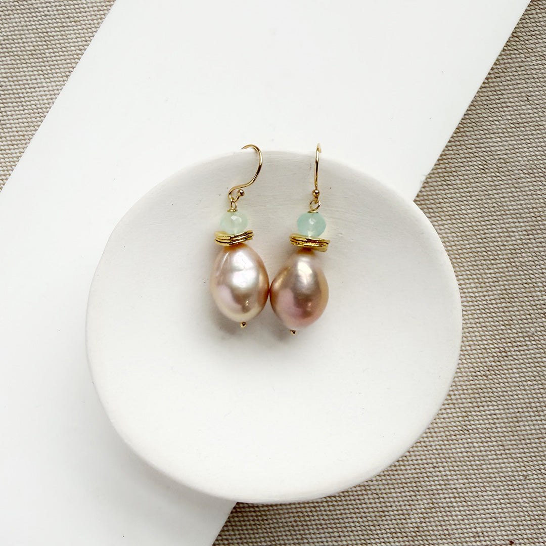 Pink pearl drop earrings in a white dish