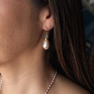 Close up of woman wearing pink pearl drop earring