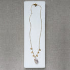 Gold and baroque pearl necklace on a white dish