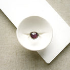 Rose cut pink sapphire mixed metal ring set in a white dish