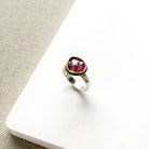 Rose cut pink sapphire mixed metal ring set on a white dish