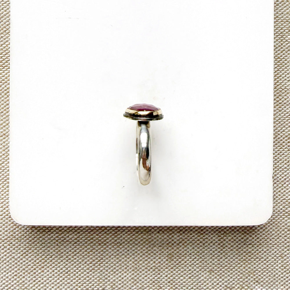 Rose cut pink sapphire mixed metal ring set on a white dish