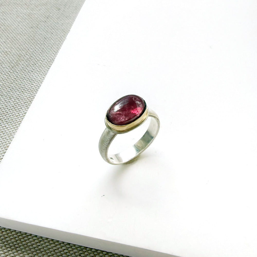 Pink tourmaline mixed metal ring on a white background