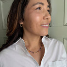 Woman wearing a white shirt and colorful gemstone necklace