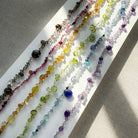 Colorful gemstone necklaces on a white surface