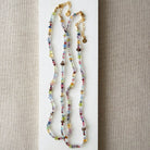 Multicolored gemstone necklace on a textured beige background