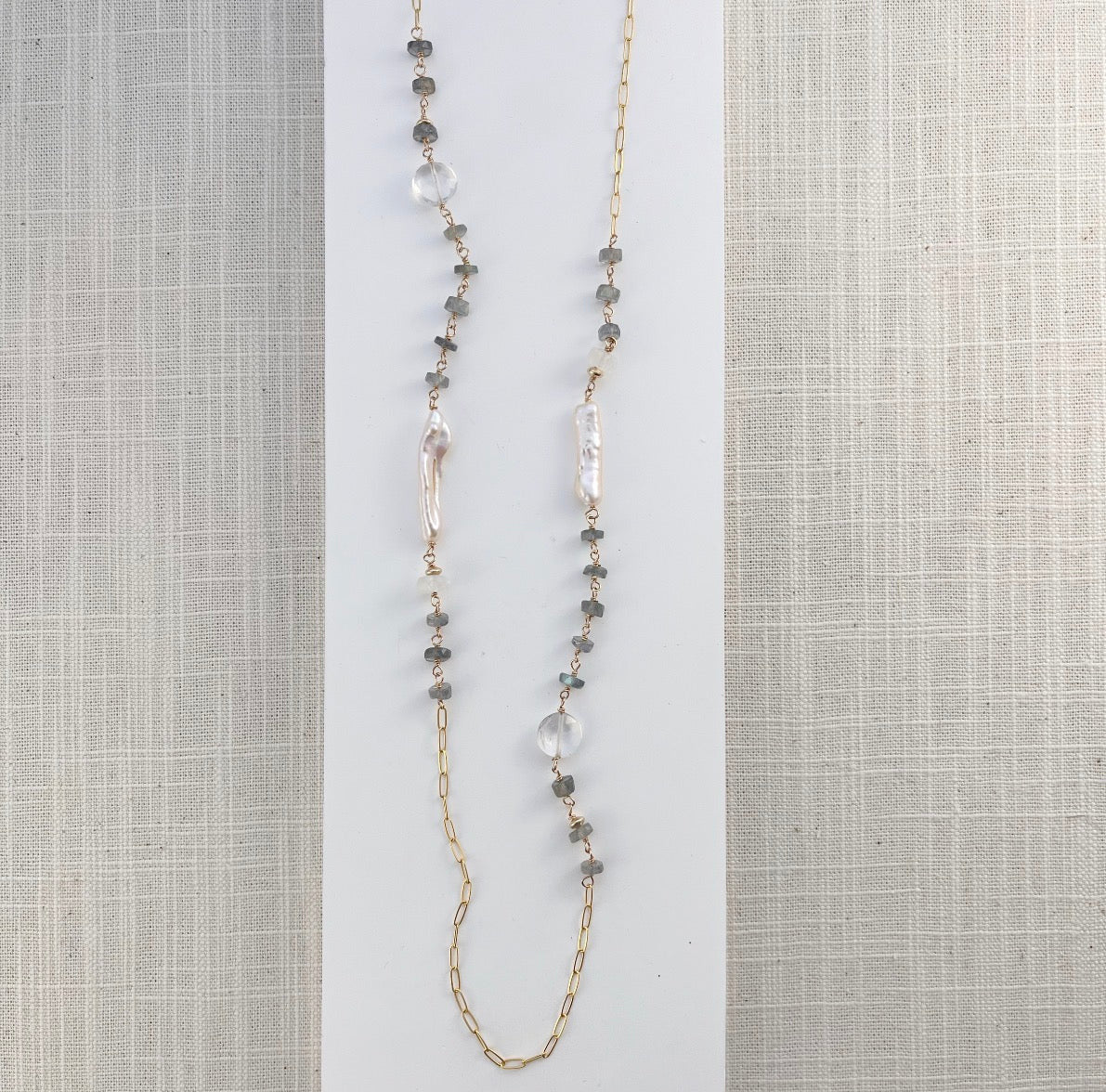 Long necklace with labradorite gems and stick pearls on a white card