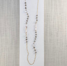 Long necklace with labradorite gems and stick pearls on a white card