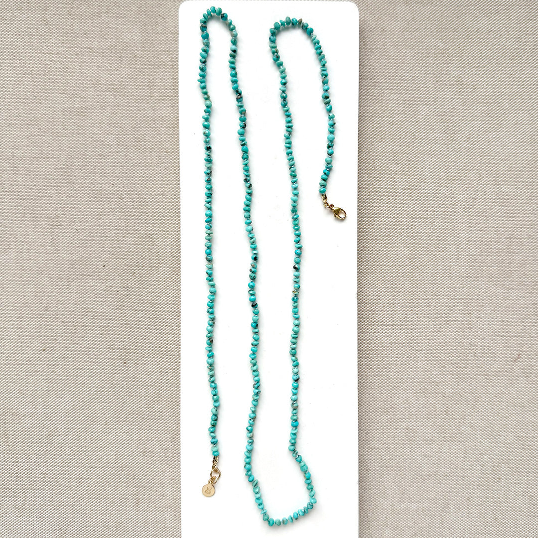 Turquoise beaded necklace on a beige card