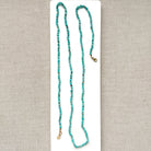 Turquoise beaded necklace on a beige card