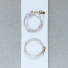 Two pearl and rose quartz bracelets with gold clasps on a white background