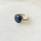 Round faceted sapphire ring on a white dish 