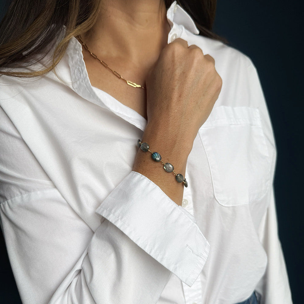 Woman wearing labradorite bracelet with a white shirt