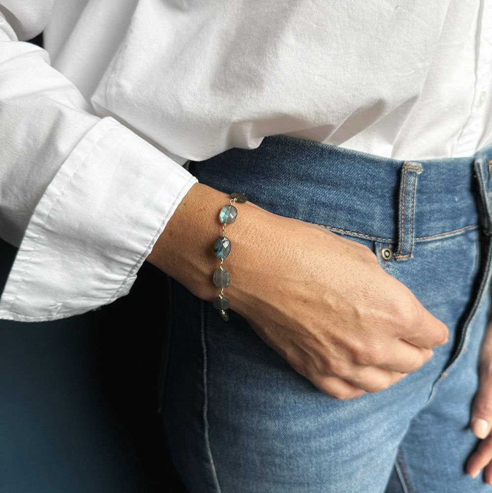 Woman wearing labradorite bracelet with a white shirt