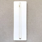 Solid gold necklace with a half moon salt and pepper diamond pendant on a white card.
