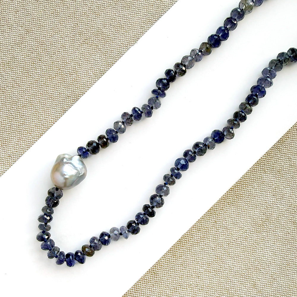 Knotted iolite gemstone necklace with gray baroque pearl on a white card