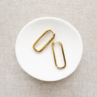 A pair of gold vermeil hoop earrings placed on a white plate.